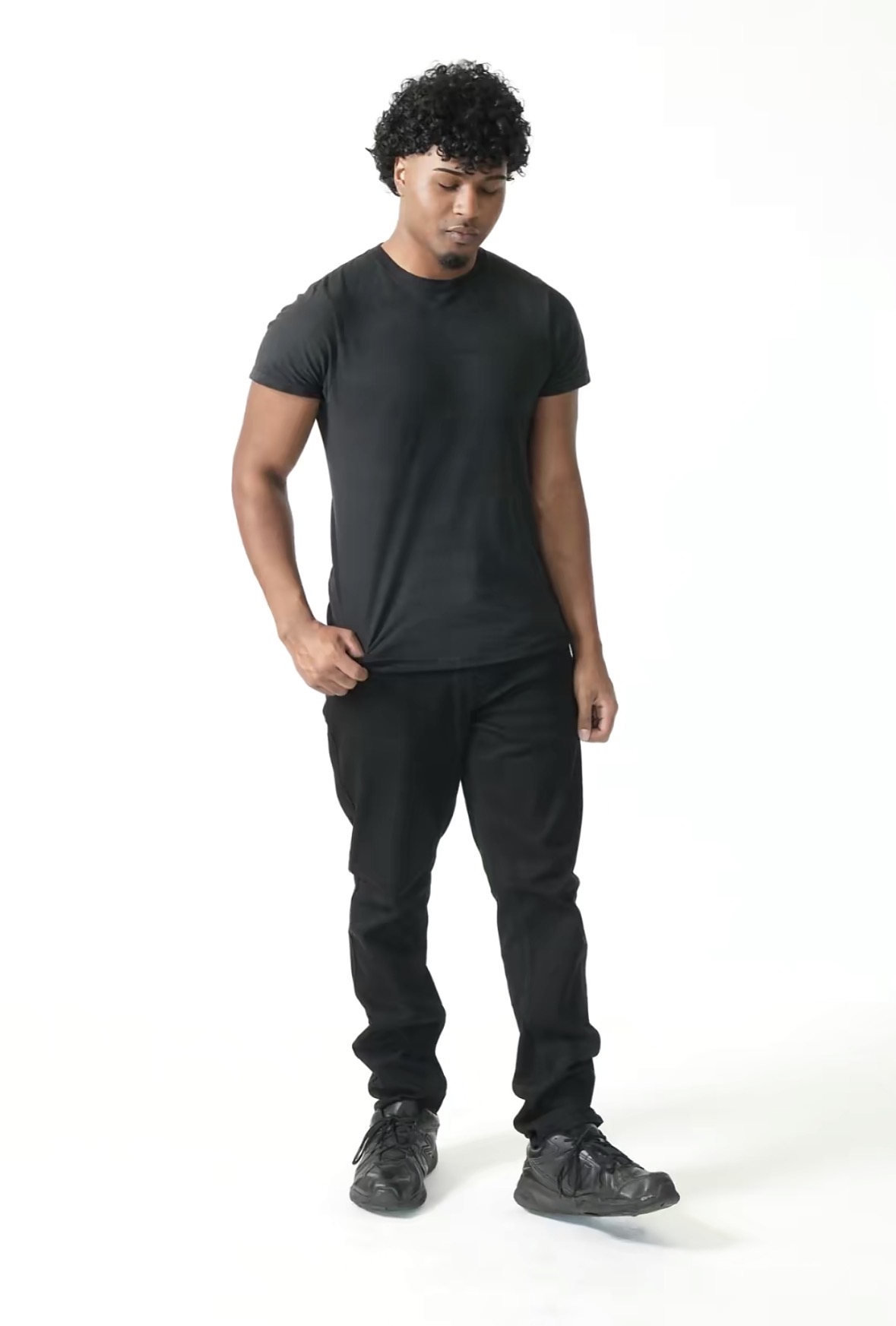 Cole in a full-length relaxed pose looking down
